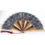 A CHINESE FAN The guards deeply carved with figures & buildings, alternate ivory, sandalwood &