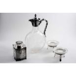A PAIR OF MODERN MOUNTED CUT-GLASS SALTS  on three legs, a plated mounted cut-glass claret jug