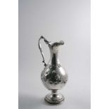 A VICTORIAN IRISH HOT WATER JUG OR EWER in the form of a vase with embossed vine decoration, a