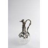A MODERN PLATED MOUNTED CUT GLASS CLARET JUG with parcel gilt vine leaves & grapes around the neck &