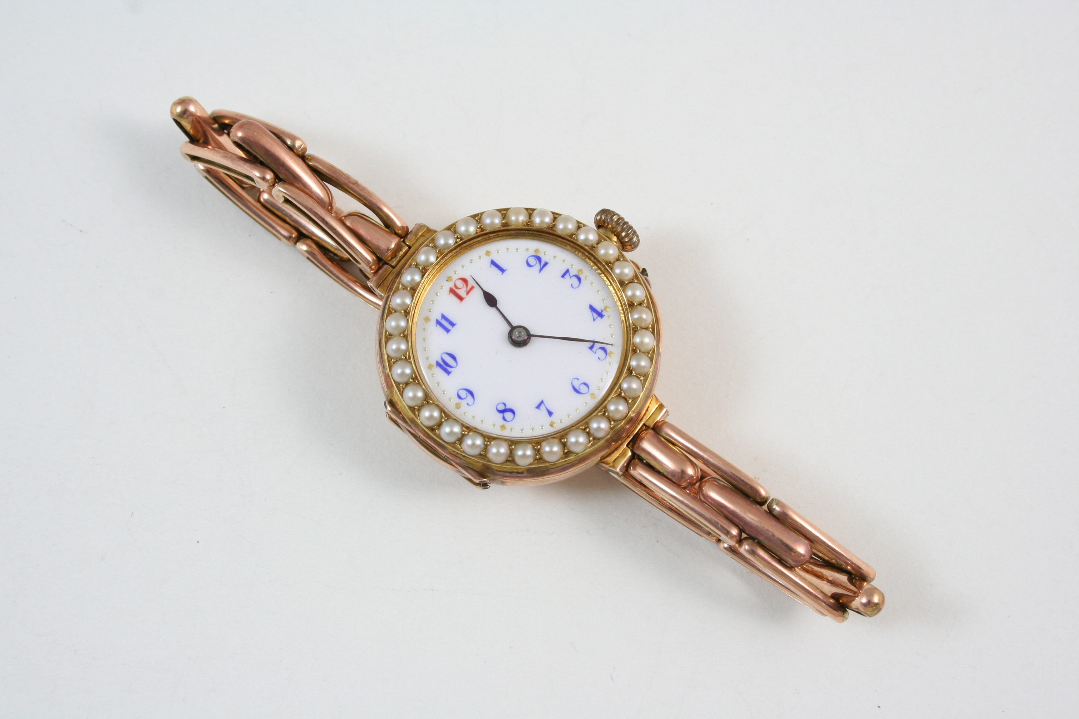 A LADY'S 9CT. GOLD WRISTWATCH BY ROLEX the circular white enamel dial with blue Arabic numerals, one