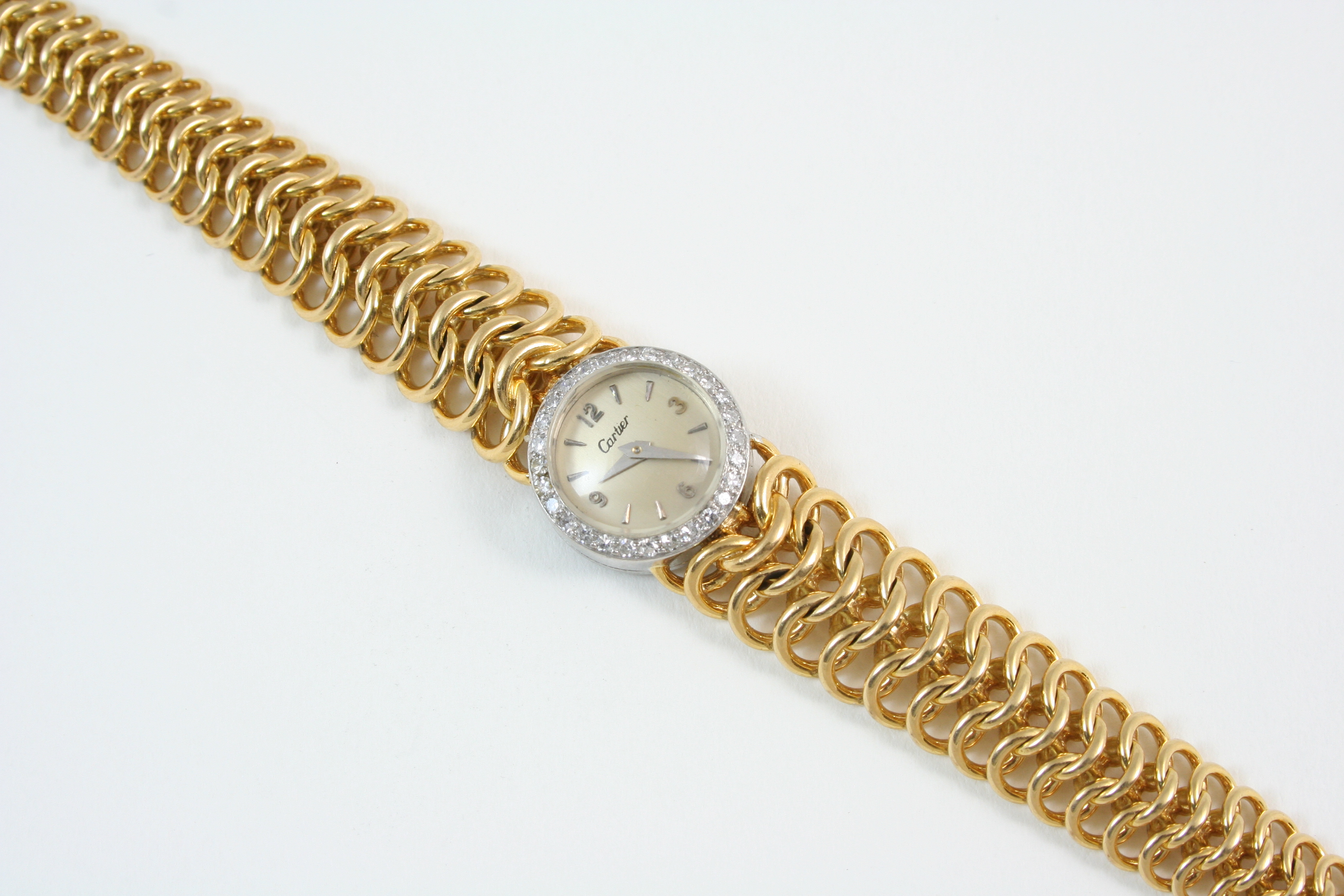 A LADY'S 18CT. GOLD AND DIAMOND WRISTWATCH BY CARTIER the signed circular dial with Arabic