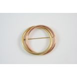 A TWO COLOUR GOLD BROOCH formed as two over lapping circles, 5.75cm. wide, 13 grams. Brooch clasp