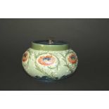 MACINTYRE MOORCROFT TOBACCO JAR painted with flowers on a green textured ground, and with a metal
