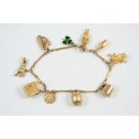 A 9CT. GOLD CHARM BRACELET set with assorted gold charms, 19 grams.