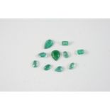 TEN ASSORTED LOOSE EMERALDS of pear, rectangular and oval shape.