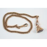 A 9CT. GOLD CURB LINK WATCH CHAIN 39cm. long, 34 grams, suspending a gold seal, mounted with