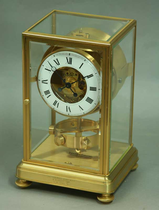 A JAEGER LE COULTRE MANTEL CLOCK with white enamel chapter ring in brass glazed case. Presentation
