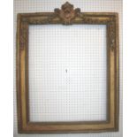 A 19th CENTURY GILT PICTURE FRAME decorated with floral swags from a central scrolled cartouche on