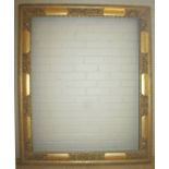 A 19th CENTURY GILT PICTURE FRAME with stylised floral reserves at the centres and corners, ribbon