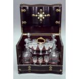 FRENCH EBONISED LIQUEUR  BOX with brass strapwork and fitted with a lift out tray with decanters and
