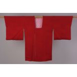 TWO SILK SHORT JAPANESE KIMONOS To include a red crepe silk with floral damask, silk covered buttons