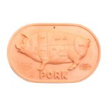 * A Brique Ware Plaque   showing a diagram of pork cuts.   Width 12 1/4 inches.   Estimate $   30-50