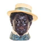 A Terra Cotta Tobacco Jar   19th/20th century   in the form of an African-American boy in a straw