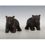 A pair of late 19th century Black Forrest carved wood bears, with inlaid glass eyes and white teeth,