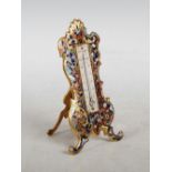 A late 19th/ early 20th century gilt metal and champleve enamel desk thermometer in the Rococo