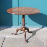 A George III mahogany snap top table, the hinged circular top raised on a baluster column with