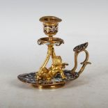 A late 19th/ early 20th century gilt metal and champleve enamel chamber candlestick, the oval base