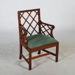 A George III style mahogany armchair in the Chinese Chippendale taste, with drop in upholstered