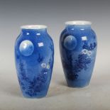 A pair of Japanese porcelain vases, decorated with flowers and foliage under moonlight, on a