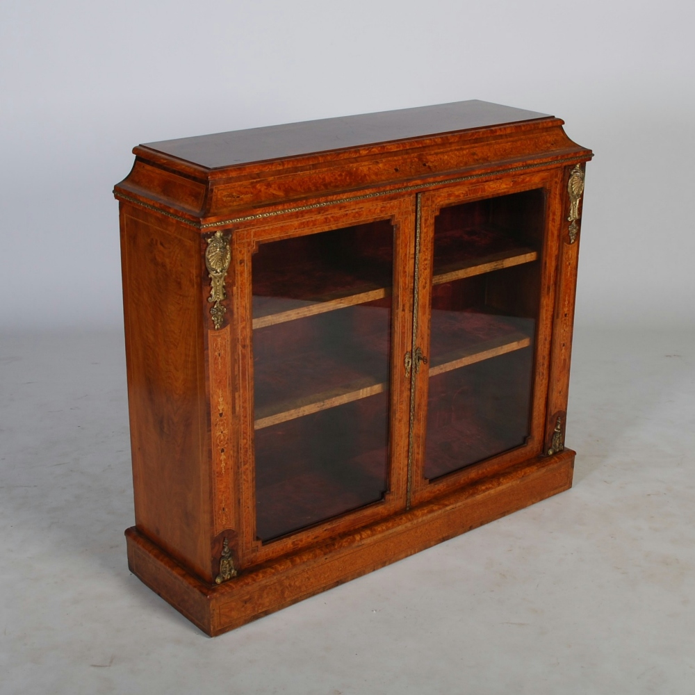 A Victorian burr walnut and gilt metal mounted bookcase, the rectangular top above a concave