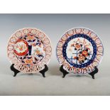 Two Japanese Imari plates, one decorated with a fenced garden of chrysanthemum and blossom within