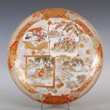 A Japanese Kutani charger, Meiji Period, decorated with shaped panels of figures and landscape views