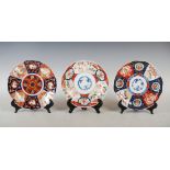 Three assorted Japanese Imari plates, each decorated with a central roundel within a floral panelled