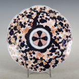 A late 19th century Japanese Imari charger, decorated with a central floral mon on a ground of