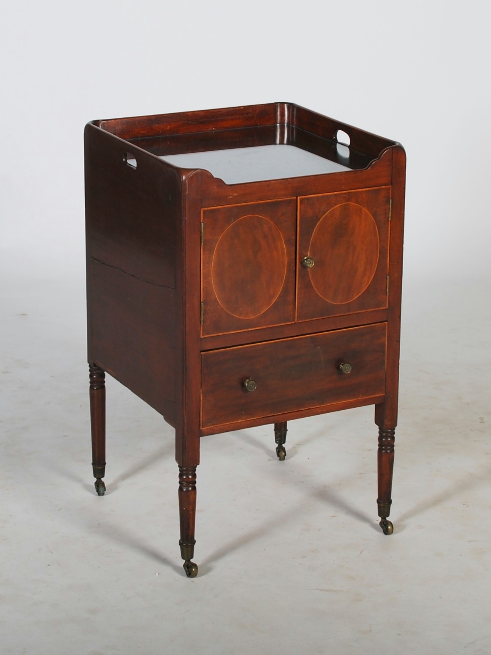 A 19th century mahogany and boxwood lined tray top commode, the pierced three quarter gallery