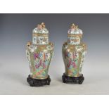 A pair of Chinese porcelain famille rose Canton jars and covers, Qing Dynasty, decorated with panels