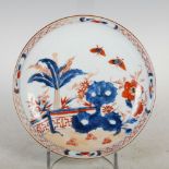 A Chinese porcelain Imari shallow dish, Qing Dynasty, decorated with a fenced garden of rockwork,