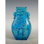 A Chinese porcelain Hu form turquoise glazed vase, decorated in relief with panels of Guanyin and