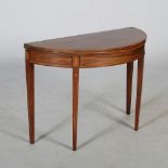 A 19th century mahogany and satinwood banded demi lune tea table, the hinged top above a plain