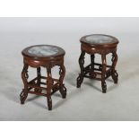 A pair of Chinese dark wood jardiniere stands, late 19th/ early 20th century, the circular tops with