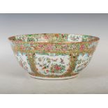 A Chinese porcelain Canton famille rose bowl, Qing Dynasty, decorated with panels of peony, birds,