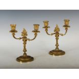 A pair of late 19th/ early 20th century ormolu two light candelabra, the foliate cast urn shaped