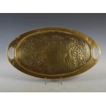 A Scottish Arts & Crafts brass oval-shaped tray, with embossed decoration of vines and leaves,