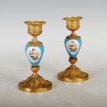 A pair of late 19th century Continental porcelain and ormolu mounted candlesticks, the urn shaped