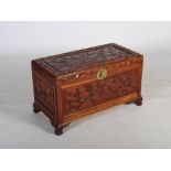 A Chinese camphor wood chest, late 19th/ early 20th century, carved with panels of prunus blossom
