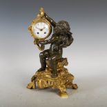 A late 19th century French Rococo style bronze mantle clock, modelled with a putti supporting a