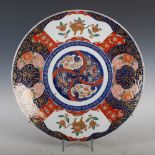 A Japanese Imari charger, late 19th/ early 20th century, decorated with a segmented roundel within a