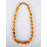 A graduated amber necklace, comprising twenty nine butterscotch amber beads, from 1cm long to 2.