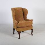 A George III mahogany and later wing armchair, the upholstered back, arms and seat raised on