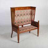 An Art Nouveau mahogany and marquetry inlaid settle, the top rail inlaid with stylised flowers and