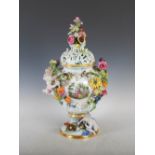 A late 19th century Meissen twin handled urn and cover, decorated with hand painted panels of