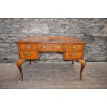 An early 20th century walnut desk by GILL & REIGATE, the rectangular top with quarter cut veneers