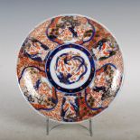 A Japanese Imari plate, late 19th/ early 20th century, decorated with a central roundel of long