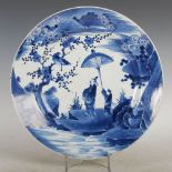 A Japanese porcelain blue and white dish, Meiji Period, decorated with a scholar and boy in a