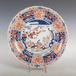 A Japanese Imari charger, Edo Period, decorated with figures in a fenced garden within a panelled